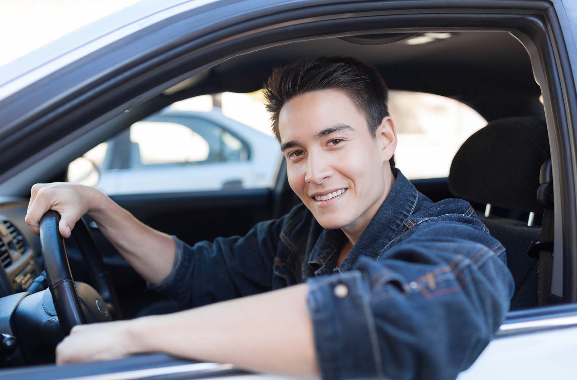 Happy young man sitting in the car